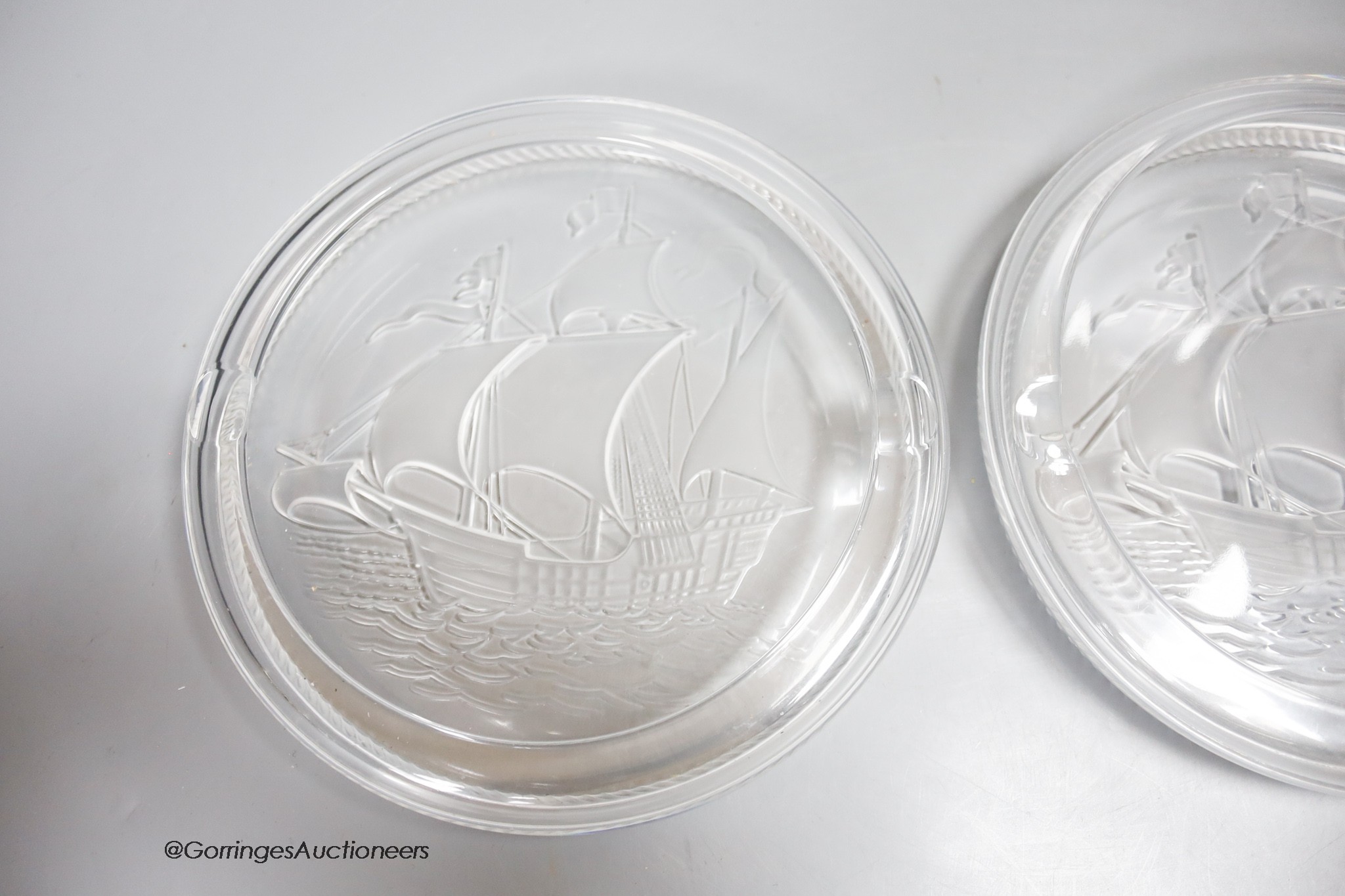 Two Lalique glass 'Santa Maria' ashtrays, moulded with clippers, signed, diameter 17cm